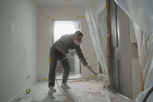 man working on painting the inside of a house